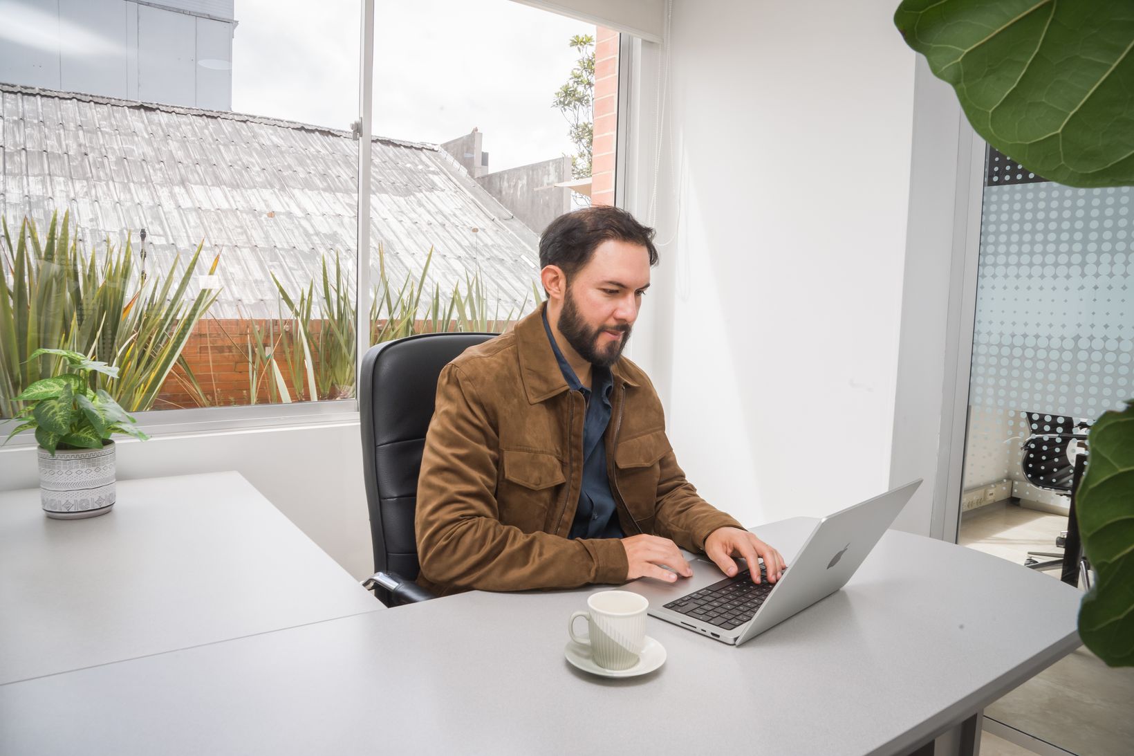 Cliente trabajando en su laptop en una oficina privada de Eva